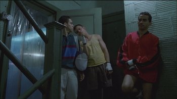 Movie still from “Girlfight” (2000), directed by Karyn Kusama – A group of young men standing next to each other in a room; Medium shot, Low angle
