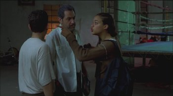 Movie still from “Girlfight” (2000), directed by Karyn Kusama – A man and a woman talking to another man in a room; Medium shot, Over the shoulder angle