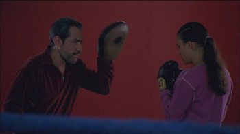 Movie still from “Girlfight” (2000), directed by Karyn Kusama – A man and a woman are boxing in a boxing ring; Medium shot, Over the shoulder angle