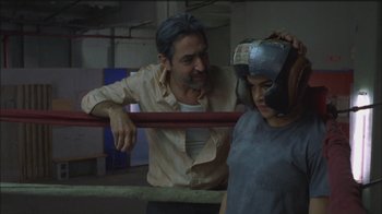 Movie still from “Girlfight” (2000), directed by Karyn Kusama – A man standing next to a woman in a boxing ring; Medium shot, Over the shoulder angle