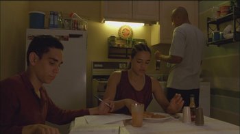 Movie still from “Girlfight” (2000), directed by Karyn Kusama – Three people sitting at a table in a kitchen; Medium shot, High angle
