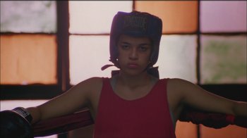 Movie still from “Girlfight” (2000), directed by Karyn Kusama – A young woman wearing a boxing hat in a boxing ring; Medium shot, Low angle