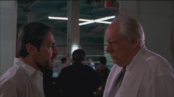 Movie still from “Girlfight” (2000), directed by Karyn Kusama – Two men in business attire talking to each other in a boxing ring; Close Up shot, Low angle