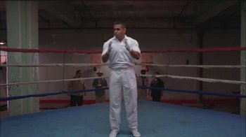 Movie still from “Girlfight” (2000), directed by Karyn Kusama – A man standing in the middle of a boxing ring; Wide shot, Low angle