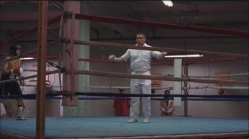 Movie still from “Girlfight” (2000), directed by Karyn Kusama – A man standing in the middle of a boxing ring; Wide shot, Low angle