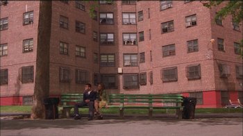 Movie still from “Girlfight” (2000), directed by Karyn Kusama – Two men sitting on a green bench in front of a building; Extreme Wide shot, High angle