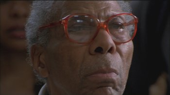 Movie still from “Girlfight” (2000), directed by Karyn Kusama – An older man wearing red glasses looking at the camera; Close Up shot, Low angle