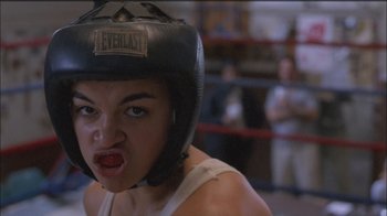 Movie still from “Girlfight” (2000), directed by Karyn Kusama – A woman wearing a boxing helmet in a boxing ring; Close Up shot, Low angle