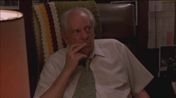 Movie still from “Girlfight” (2000), directed by Karyn Kusama – An older man sitting in a chair with his hand to his face; Close Up shot, Over the shoulder angle