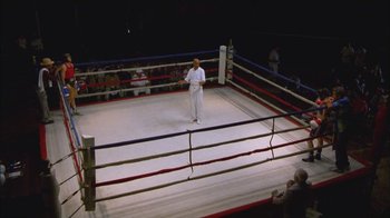 Movie still from “Girlfight” (2000), directed by Karyn Kusama – A man standing in the middle of a boxing ring; Wide shot, High angle