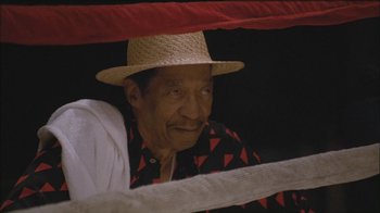 Movie still from “Girlfight” (2000), directed by Karyn Kusama – An older man wearing a straw hat and a red and black shirt; Close Up shot, Low angle