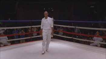 Movie still from “Girlfight” (2000), directed by Karyn Kusama – A man in a boxing ring wearing a white outfit; Wide shot, Low angle