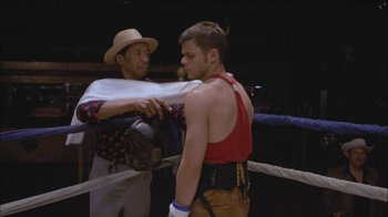 Movie still from “Girlfight” (2000), directed by Karyn Kusama – Two men in a boxing ring one is wearing a hat and the other is wearing a red shirt; Medium shot, Over the shoulder angle