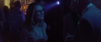 Movie still from “Gloria Bell” (2018), directed by Sebastián Lelio – A woman with glasses is holding a drink in her hand; Medium shot, Over the shoulder angle