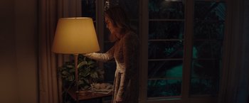 Movie still from “Gloria Bell” (2018), directed by Sebastián Lelio – A woman standing next to a lamp in a room; Medium shot, High angle