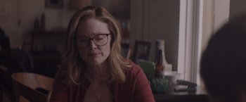 Movie still from “Gloria Bell” (2018), directed by Sebastián Lelio – A woman sitting at a table in a living room; Close Up shot, Over the shoulder angle