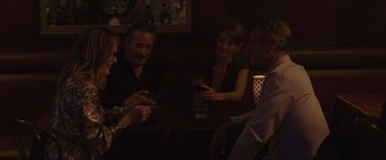 Movie still from “Gloria Bell” (2018), directed by Sebastián Lelio – A group of people sitting at a table with drinks; Medium shot, Over the shoulder angle