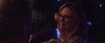 Movie still from “Gloria Bell” (2018), directed by Sebastián Lelio – A woman wearing glasses sitting at a table; Close Up shot, Over the shoulder angle