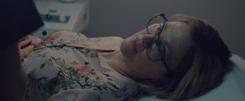Movie still from “Gloria Bell” (2018), directed by Sebastián Lelio – A woman wearing glasses laying on the ground; Close Up shot, Over the shoulder angle