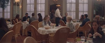 Movie still from “Gloria Bell” (2018), directed by Sebastián Lelio – A group of people sitting at a table in a restaurant; Wide shot, Over the shoulder angle