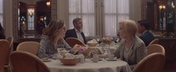Movie still from “Gloria Bell” (2018), directed by Sebastián Lelio – A group of people sitting at a table in front of a window; Medium shot, Over the shoulder angle
