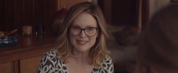 Movie still from “Gloria Bell” (2018), directed by Sebastián Lelio – A person wearing glasses and smiling; Close Up shot, Over the shoulder angle