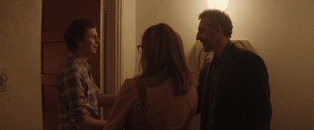 Movie still from “Gloria Bell” (2018), directed by Sebastián Lelio – A group of people standing next to each other in a room; Medium shot, Over the shoulder angle