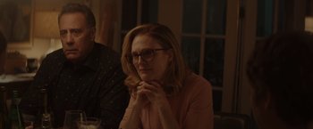 Movie still from “Gloria Bell” (2018), directed by Sebastián Lelio – A woman sitting at a table with her hands clasped together; Close Up shot, Over the shoulder angle