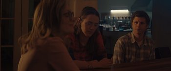 Movie still from “Gloria Bell” (2018), directed by Sebastián Lelio – A woman sitting at a table looking at a phone; Medium shot, Over the shoulder angle