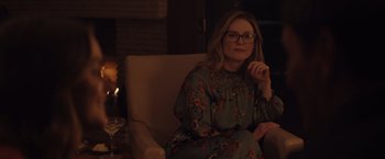 Movie still from “Gloria Bell” (2018), directed by Sebastián Lelio – A woman sitting in a chair in front of a fireplace; Medium shot, Over the shoulder angle