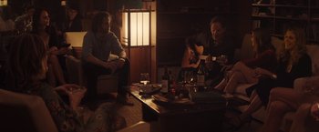 Movie still from “Gloria Bell” (2018), directed by Sebastián Lelio – Two men sitting in a living room playing a guitar; Medium shot, Over the shoulder angle