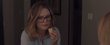 Movie still from “Gloria Bell” (2018), directed by Sebastián Lelio – A woman with glasses is holding a piece of food; Close Up shot, Over the shoulder angle