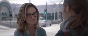 Movie still from “Gloria Bell” (2018), directed by Sebastián Lelio – A woman wearing glasses standing next to a traffic light; Close Up shot, Over the shoulder angle