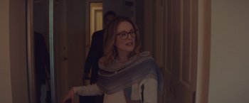 Movie still from “Gloria Bell” (2018), directed by Sebastián Lelio – A woman with a scarf around her neck and wearing glasses; Medium shot, Over the shoulder angle