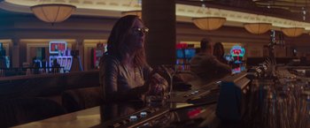Movie still from “Gloria Bell” (2018), directed by Sebastián Lelio – A woman sitting at a bar with a drink in her hand; Medium shot, Over the shoulder angle