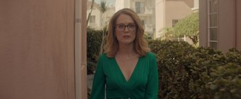 Movie still from “Gloria Bell” (2018), directed by Sebastián Lelio – A woman in a green dress standing in front of a building; Medium shot, Over the shoulder angle