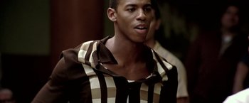 Movie still from “Glory Road” (2006), directed by James Gartner – A young man in a striped shirt looking at the camera; Close Up shot, Over the shoulder angle