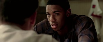 Movie still from “Glory Road” (2006), directed by James Gartner – A man sitting in front of another man in front of a wall; Close Up shot, Over the shoulder angle