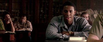 Movie still from “Glory Road” (2006), directed by James Gartner – A man sitting at a table with a book in front of him; Close Up shot, Over the shoulder angle