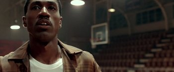 Movie still from “Glory Road” (2006), directed by James Gartner – A man standing in front of a basketball court; Close Up shot, Low angle