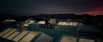 Movie still from “Glory Road” (2006), directed by James Gartner – Two people sitting on a ledge at night with candles; Extreme Wide shot, High angle
