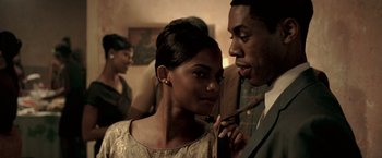 Movie still from “Glory Road” (2006), directed by James Gartner – A man and a woman standing next to each other in a room; Close Up shot, Over the shoulder angle