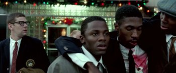 Movie still from “Glory Road” (2006), directed by James Gartner – A man wearing a suit and tie with another man standing behind him; Close Up shot, High angle