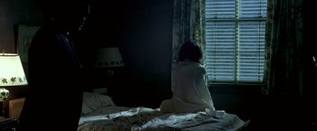 Movie still from “Glory Road” (2006), directed by James Gartner – A woman sitting on a bed looking out a window; Medium shot, High angle