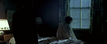 Movie still from “Glory Road” (2006), directed by James Gartner – A woman sitting on a bed looking out a window; Medium shot, Over the shoulder angle