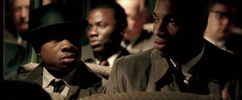 Movie still from “Glory Road” (2006), directed by James Gartner – A group of men sitting next to each other in a room; Close Up shot, Over the shoulder angle