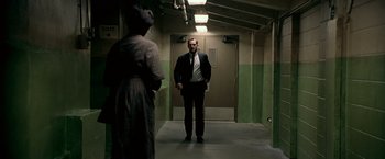 Movie still from “Glory Road” (2006), directed by James Gartner – A man in a suit and tie standing in a hallway; Wide shot, Low angle