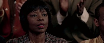 Movie still from “Glory Road” (2006), directed by James Gartner – A woman in a checkered shirt is looking at the camera; Close Up shot, Over the shoulder angle