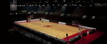 Movie still from “Glory Road” (2006), directed by James Gartner – An empty basketball court with a photographer taking a picture; Extreme Wide shot, High angle