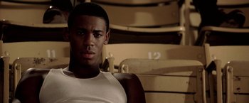 Movie still from “Glory Road” (2006), directed by James Gartner – A young man sitting in a chair in front of an audience; Close Up shot, High angle